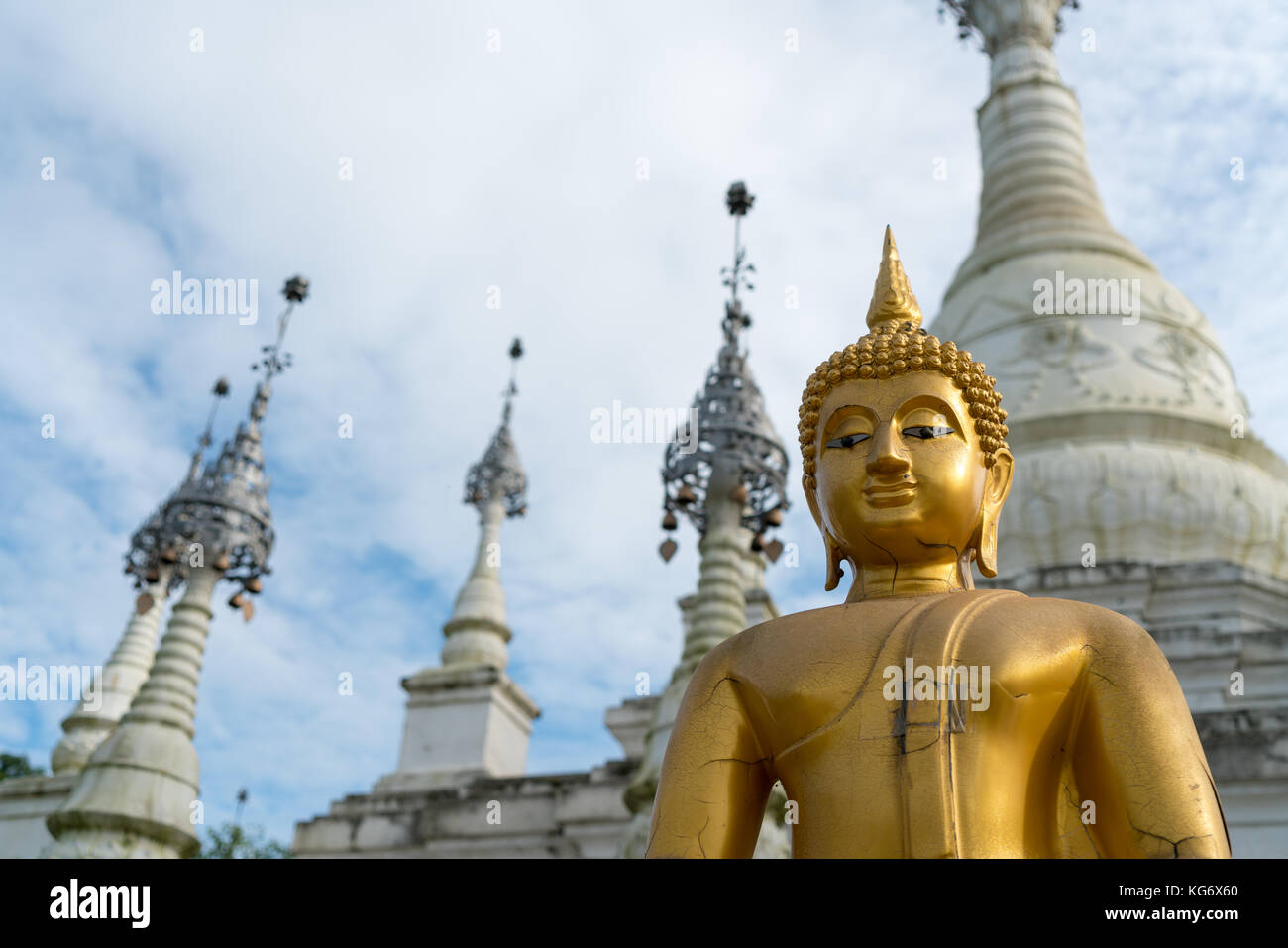Traditionelle Buddha-Figur und Tempel im thailändischen Stil aus einem niedrigen Winkel im Yunnan Nationalitätendorf in Kunming, China Stockfoto