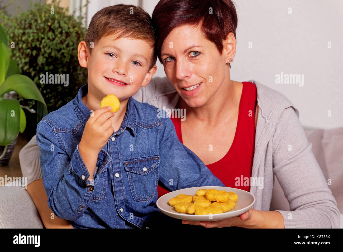 Mutter und Sohn essen Chicken Nuggets Stockfoto