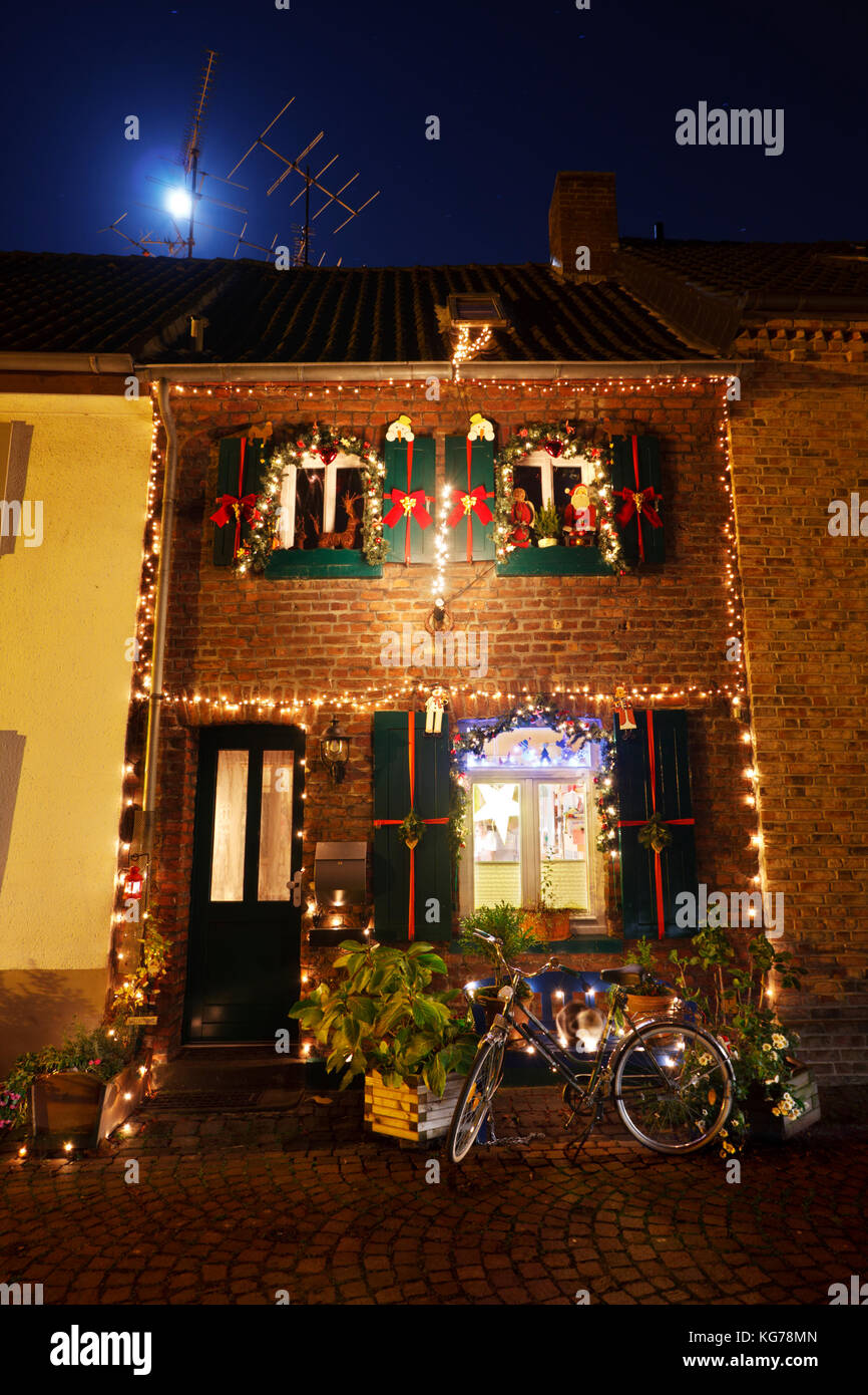 Ein kleines Stadthaus mit Weihnachten Dekoration in der Nacht, der Mond scheint. Stockfoto