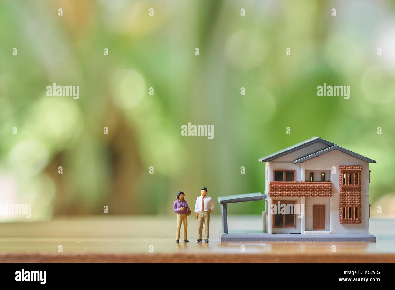 Miniatur 2 Leute stehen Modell Haus Modell. Als Hintergrund Immobilien Konzept mit kopieren. Stockfoto
