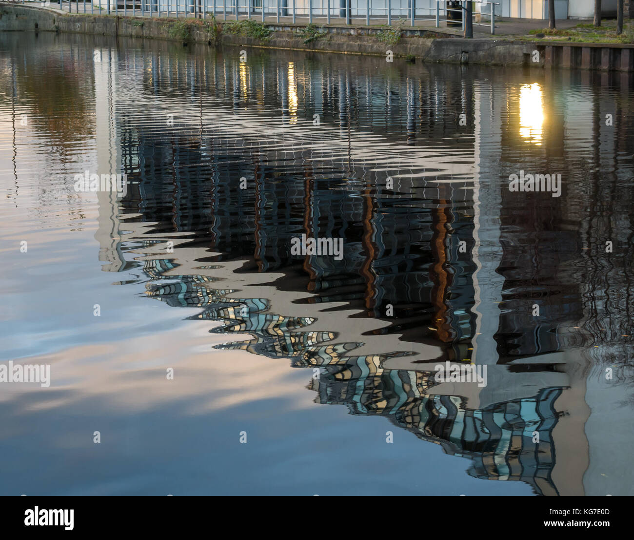 Reflexionen der modernen Mehrfamilienhaus in ruhigem Wasser Wasser von Leith Fluss, Erstellen von Welligen abstrakte Muster, Edinburgh, Schottland, Großbritannien Stockfoto