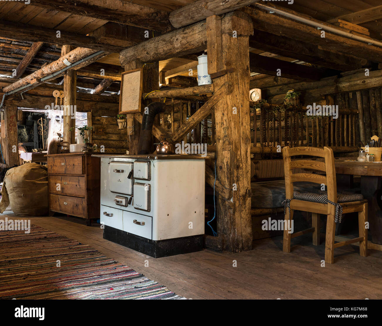Habachtal, Österreich - 28. September 2017: Innenraum der alten Holzhütte 'Thuringer Hutte' mit dicken Balken und altem Ofen, Stühlen und Tabel Stockfoto