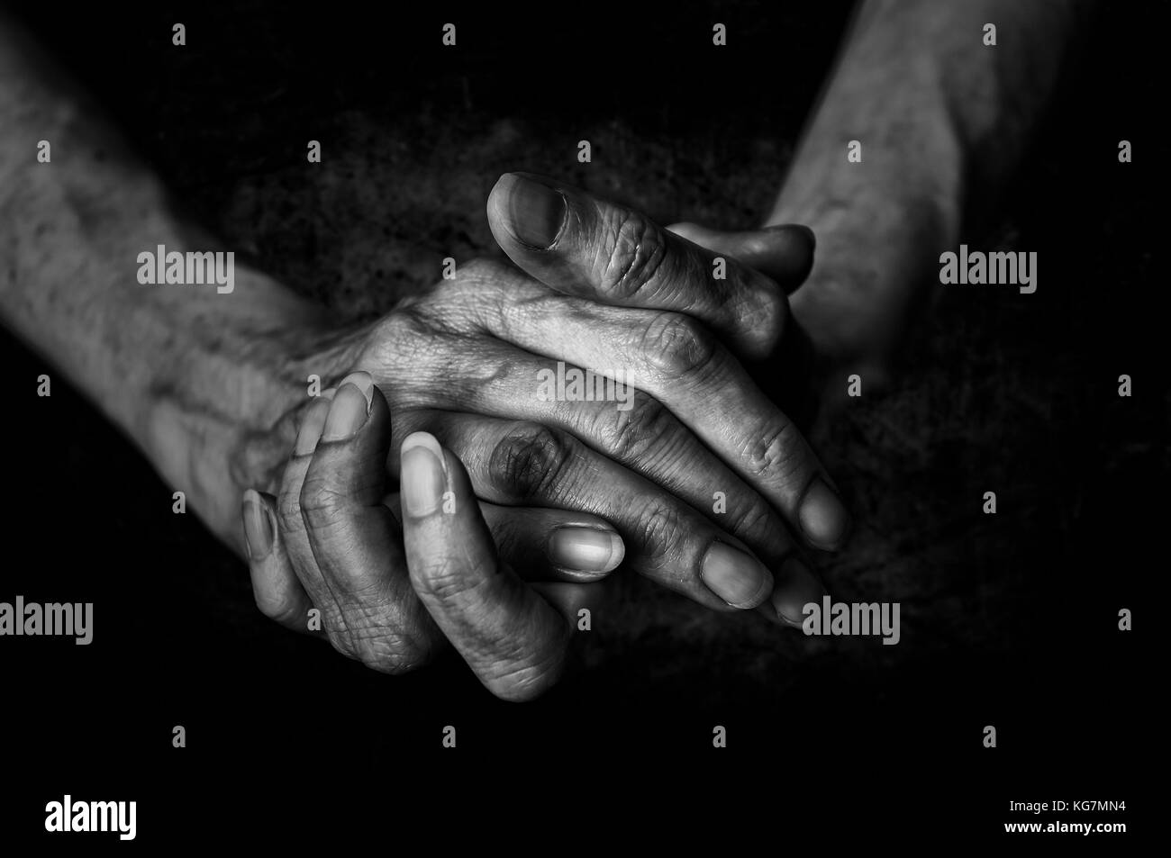 Schwarz-weiß Foto von älteren Frau Hände auf schwarzem Hintergrund Stockfoto