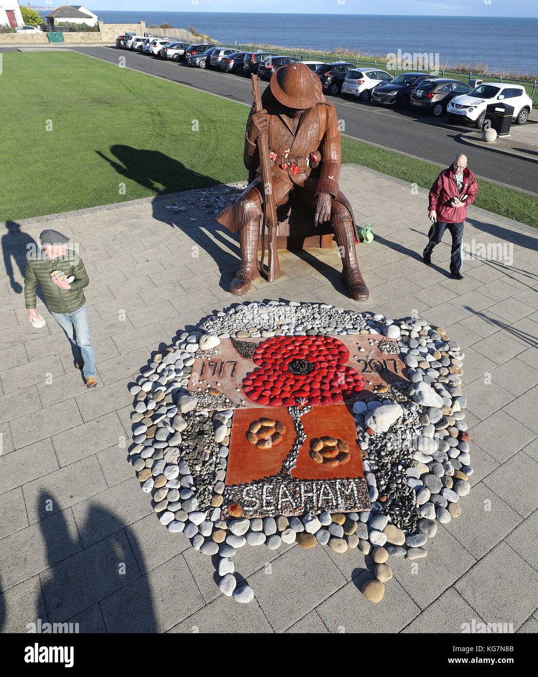 David McKenna (links), 51, und Philip Ridley, 45, die beide im Royal Regiment of Fusiliers dienten, erstellen eine Anzeige, Früchte des Meeres, aus Muscheln am Fuße der Tommy-Statue in Seaham, Co Durham, zum Waffenstillstandstag gemacht. Stockfoto