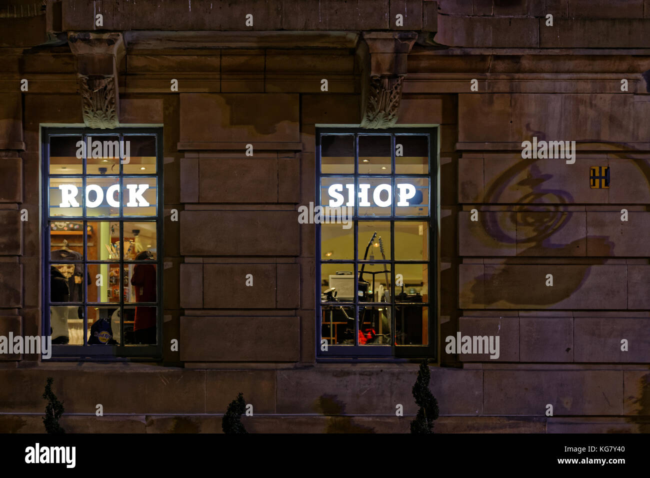 Nacht in der Rock Shop im Hard Rock Cafe durch Straße Fenster mit den Schatten seiner street sign Buchanan Street, Glasgow, Vereinigtes Königreich Stockfoto