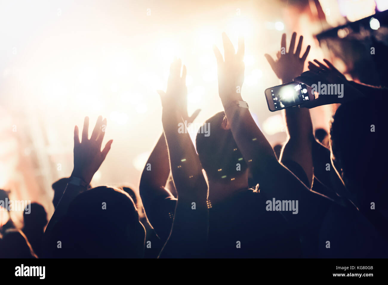 Jubelnde Menge mit Händen in der Luft bei Music Festival Stockfoto