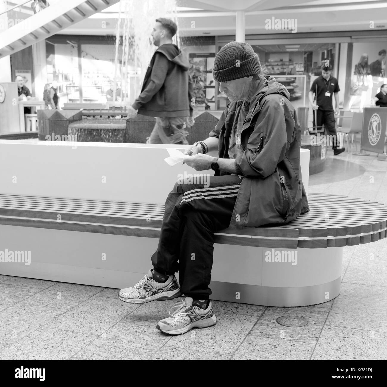 Oktober 2017 - Ältere Kerl Überprüfung seiner Quittungen in Cribbs Causeway Einkaufszentrum Mall in der Nähe von Bristol in Südwestengland. Stockfoto