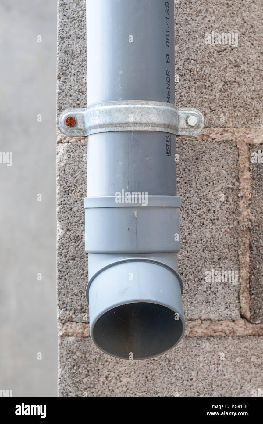 Industrielle Wasser ablassen PVC-Rohr mit Betonklotz im Hintergrund Stockfoto