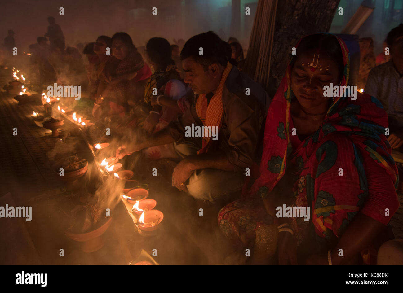 Dhaka, Bangladesch. 4. November 2017. Anhänger besuchen Gebet mit Räucherstäbchen und leichte Öl-Lampen vor dem Fasten während ein Religiöses Festival am 4. November 2017 rief Rakher Upabash in Dhaka. Bengalischen Volkes des hinduistischen Glaubens in Bangladesch sitzen im Gebet zur Feier des 18. Jahrhunderts hinduistischen heiligen Baba Lokenath mit einem 'Rakher Upobas "Gebet und Fasten Tag jedes Jahr Tausende von hinduistischen Gläubigen vor Shri Shri Lokenath Brahmachari Ashram Tempel für die kartik Das brati oder Rakher Upobash religiöses Fest in Barodi, in der Nähe von Dhaka, Bangladesch sammeln. Credit: Azim Khan Ronnie/Alamy leben Nachrichten Stockfoto Dhaka, Bangladesch. 4. November 2017. Anhänger besuchen Gebet mit Räucherstäbchen und leichte Öl-Lampen vor dem Fasten während ein Religiöses Festival am 4. November 2017 rief Rakher Upabash in Dhaka. Bengalischen Volkes des hinduistischen Glaubens in Bangladesch sitzen im Gebet zur Feier des 18. Jahrhunderts hinduistischen heiligen Baba Lokenath mit einem 'Rakher Upobas "Gebet und Fasten Tag jedes Jahr Tausende von hinduistischen Gläubigen vor Shri Shri Lokenath Brahmachari Ashram Tempel für die kartik Das brati oder Rakher Upobash religiöses Fest in Barodi, in der Nähe von Dhaka, Bangladesch sammeln. Credit: Azim Khan Ronnie/Alamy leben Nachrichten Stockfoto