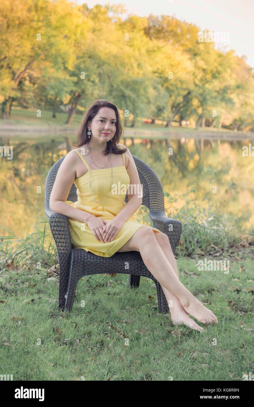 Frau im Herbst vor einem Bach mit der Reflexion auf den Bäumen. Stockfoto