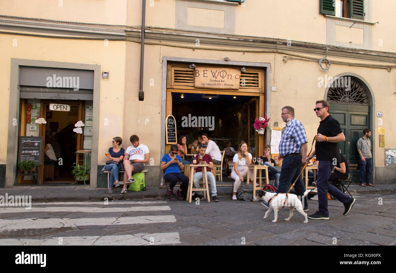 Street Scene übersicht Gönner Entspannung in einem florentinischen Pflaster Restaurant als Fußgänger mit einem Hund Spaziergänge durch Stockfoto