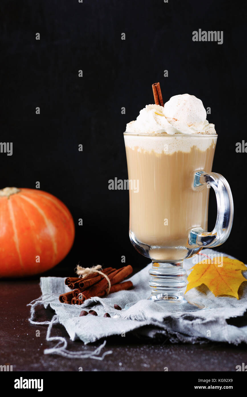 Pumpkin spice Latte oder Kaffee mit Sahne, Zimt und Marshmallows in Glas mug über schwarzen Hintergrund. Vertikale, kopieren Platz für Text Stockfoto