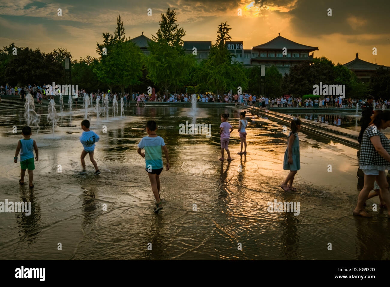 Kinder, die in einem Brunnen bei Sonnenuntergang in Xi'an, China - August 2017 Stockfoto