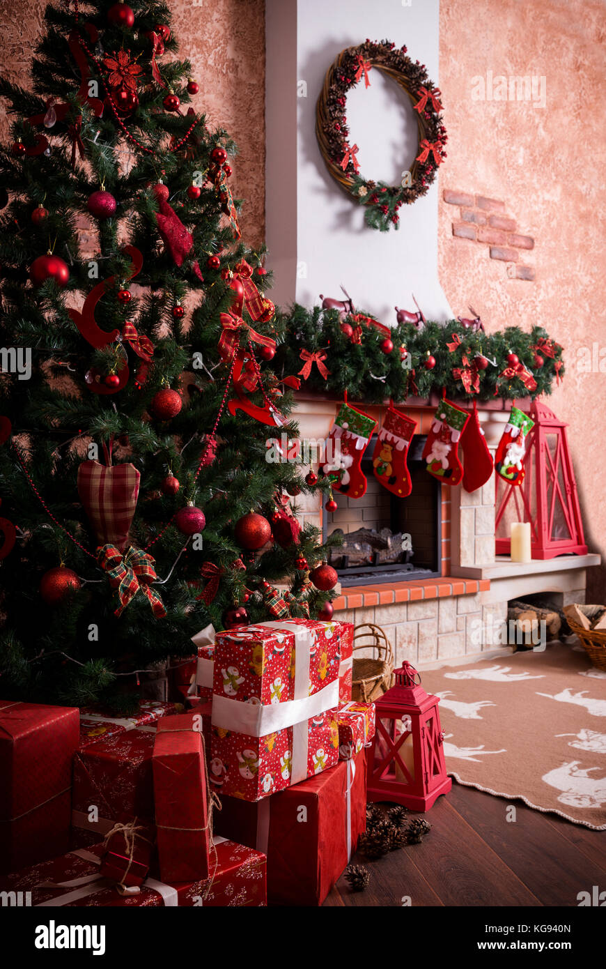 Viele Kartons mit Weihnachten Geschenke unter dem Weihnachtsbaum in der Nähe der Feuerstelle. Stockfoto