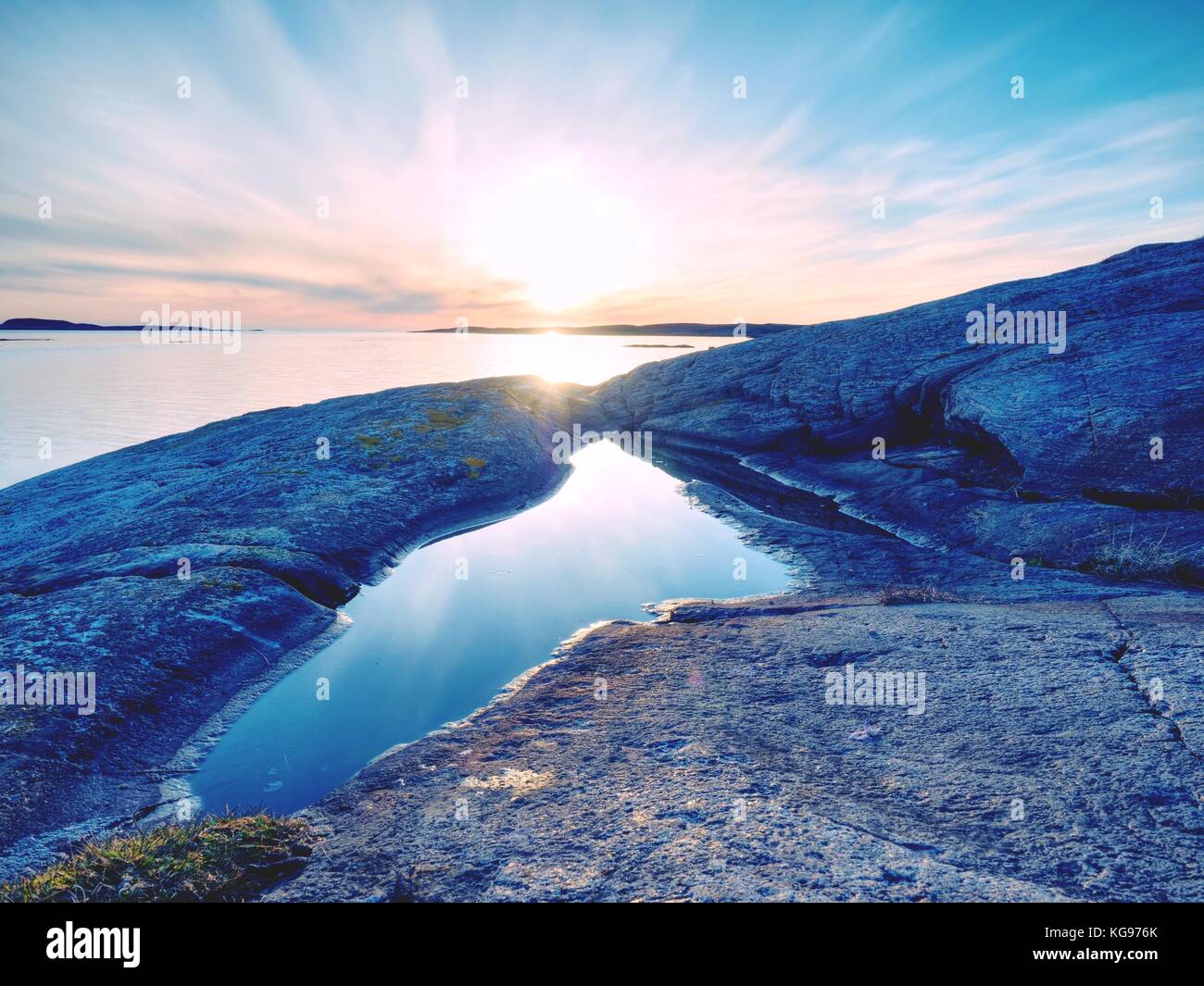 Schöne Seascape anzeigen. Die Spiegelung von sunsetting Horizont im Wasser Pools in den Felsen. Glatte Ozean mit hellblauen Himmel und Wolken blured. Der su Stockfoto