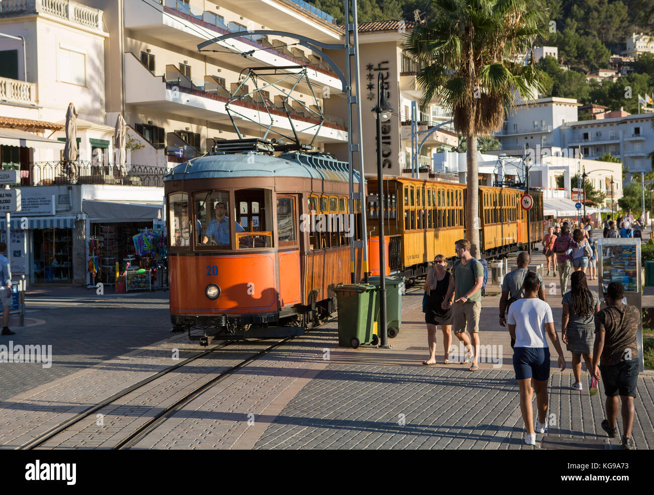 Alte hölzerne Straßenbahn fährt mit der Straßenbahn, Touristen laufen auf dem Bürgersteig, Port de Soller, Mallorca, Balearen, Spanien. Stockfoto