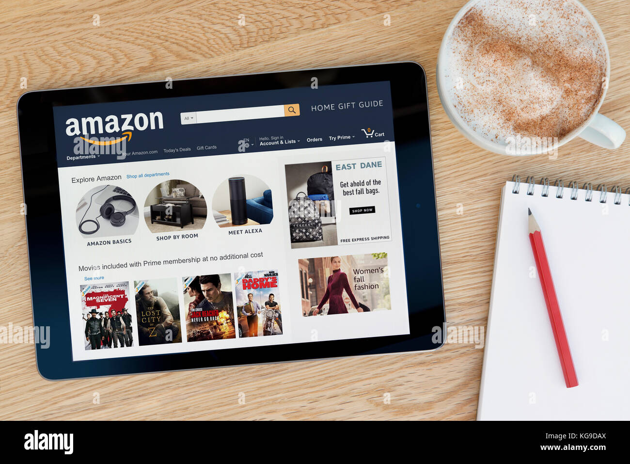 Die Amazon Website Funktionen auf einem iPad Tablet Gerät, das auf einem Tisch liegt neben einem Notizblock und Bleistift und eine Tasse Kaffee (nur redaktionell) Stockfoto