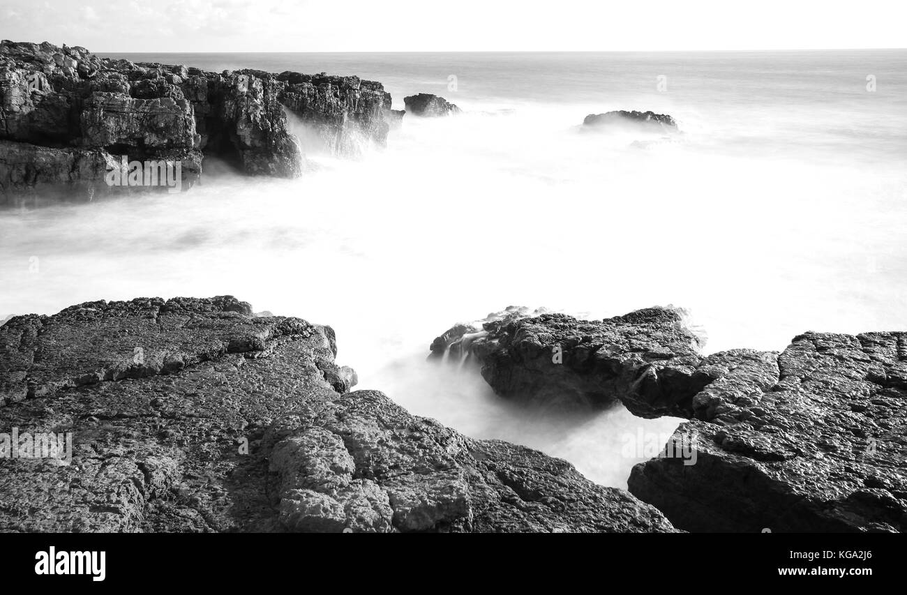 Lange Belichtung von Felsen und Meer in der portugiesischen Küste Stockfoto