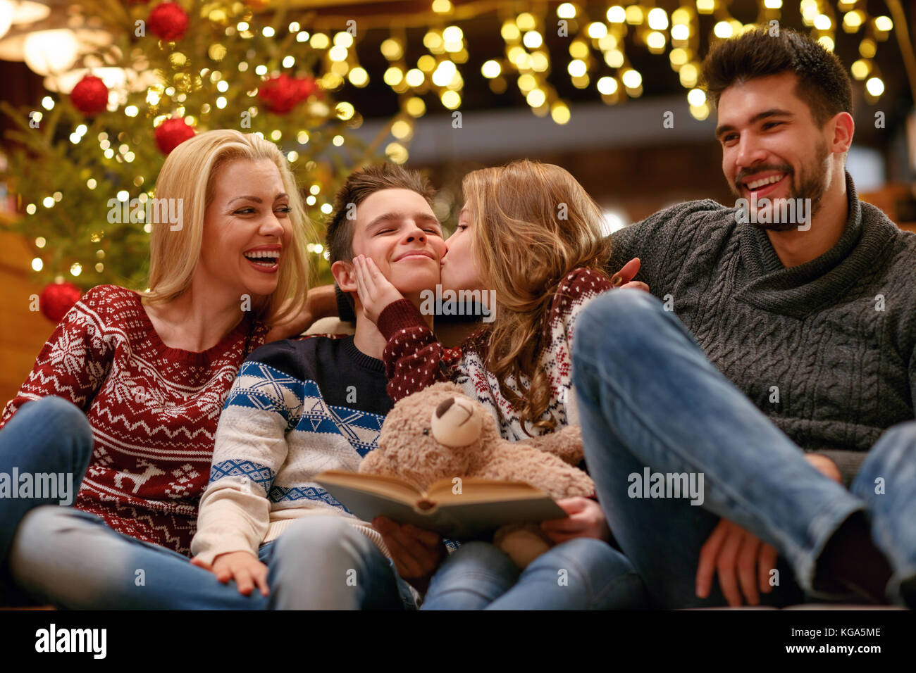Glückliche Schwester küssen ihr Bruder für Heiligabend mit Eltern verbracht Stockfoto