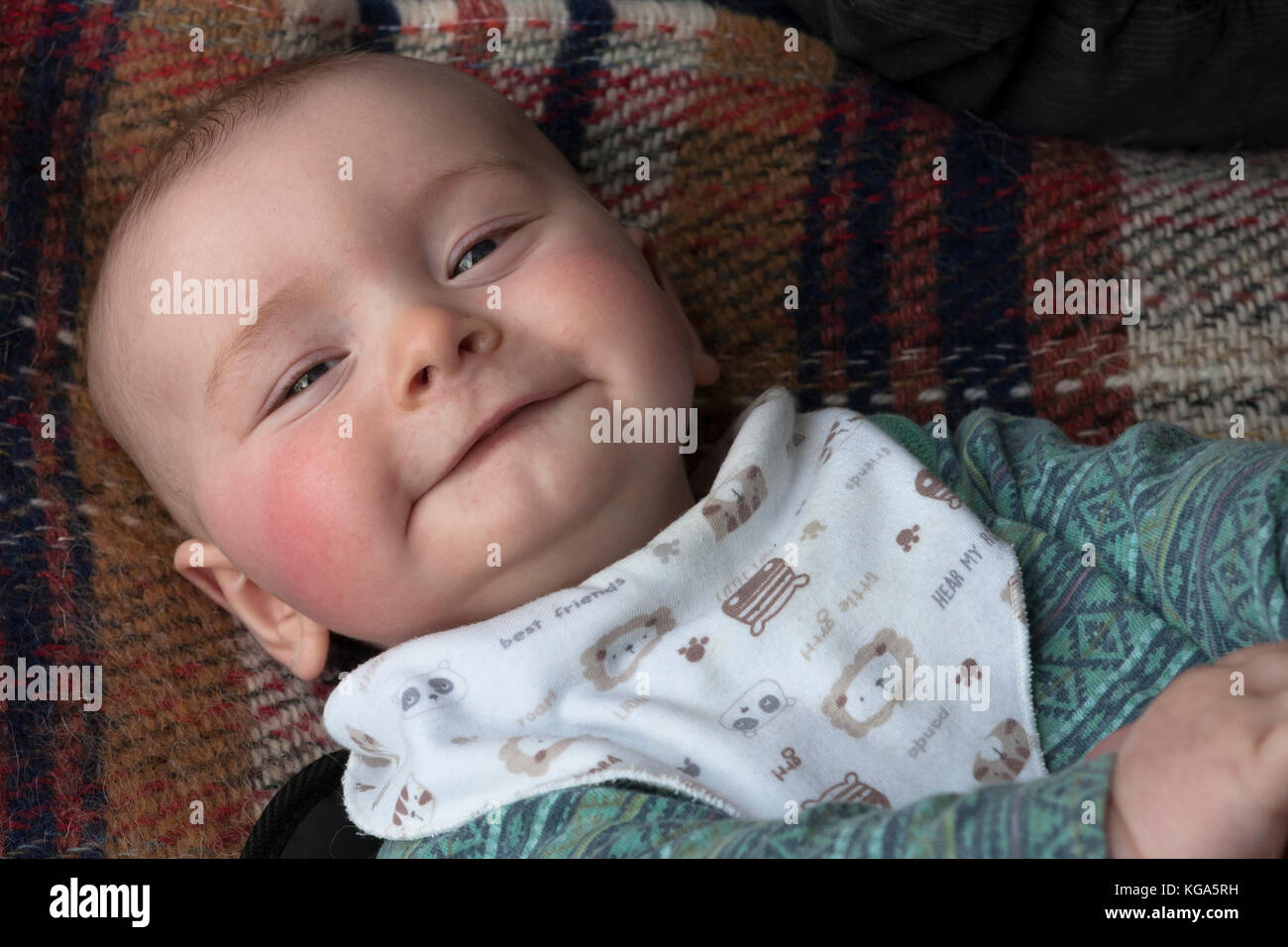 Baby Junge, etwa sechs Monate alt, lächelnd glücklich in Nahaufnahme MODELL VERÖFFENTLICHT Stockfoto