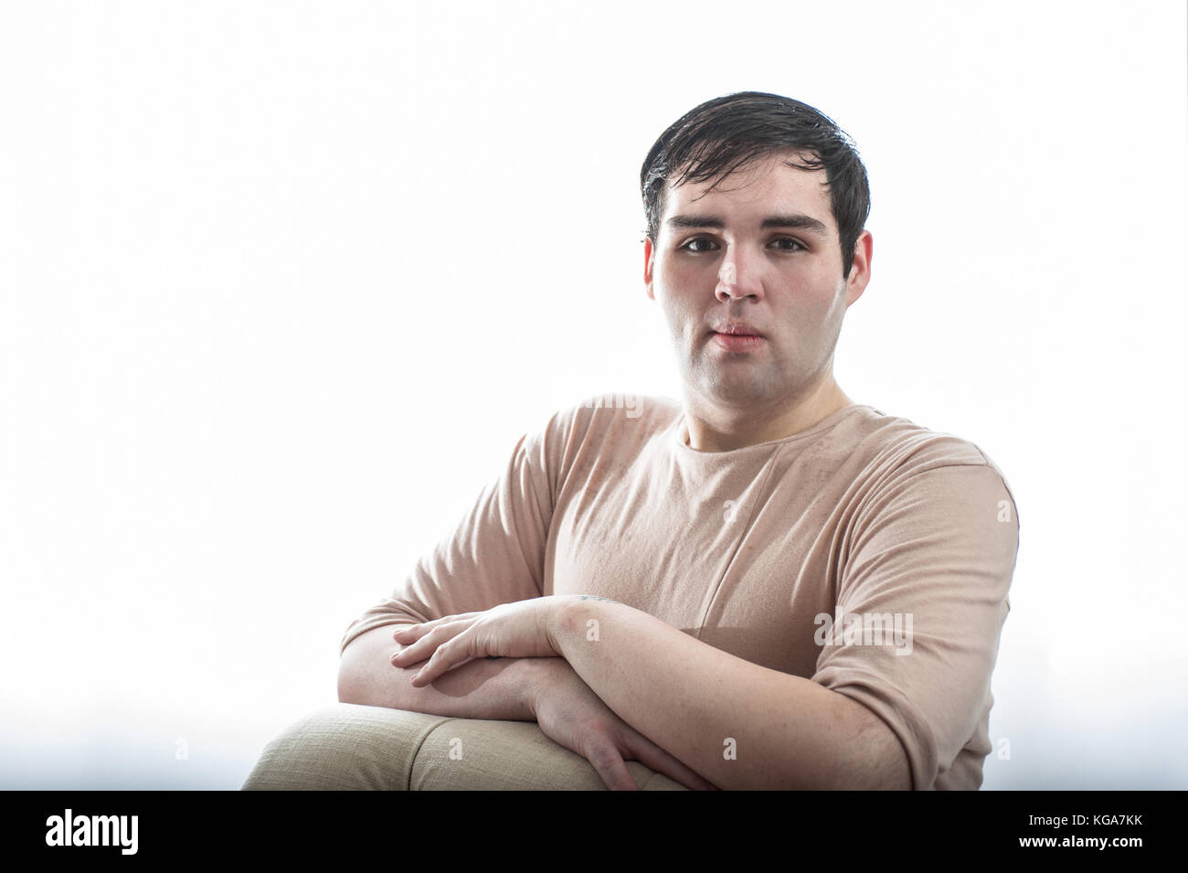 Fair dunkelhäutige junge Mann lehnte sich mit Arme gefaltet. Stockfoto