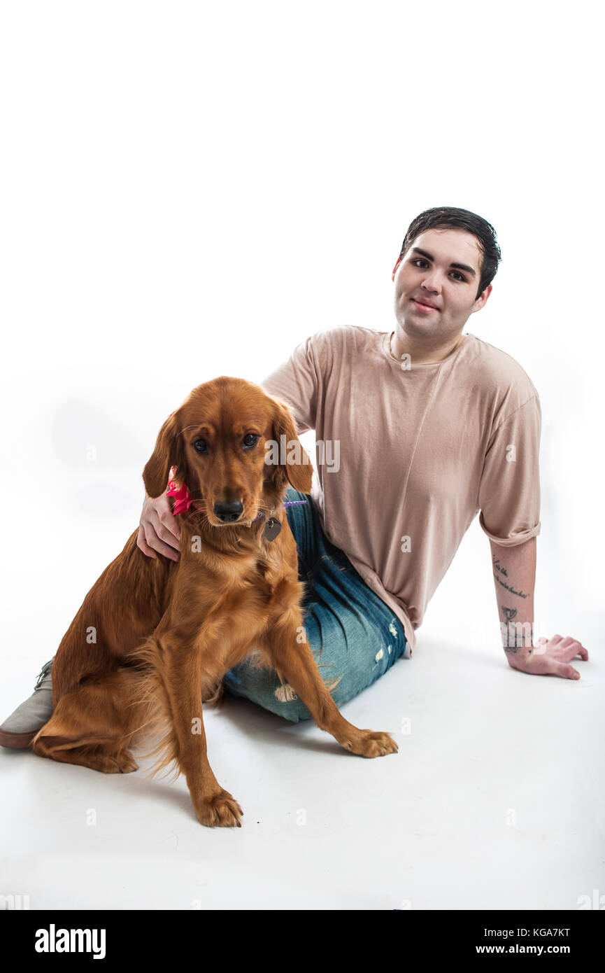 Fair dunkelhäutige Mann im Moment mit seinem Golden Retriever auf dem Boden. Stockfoto