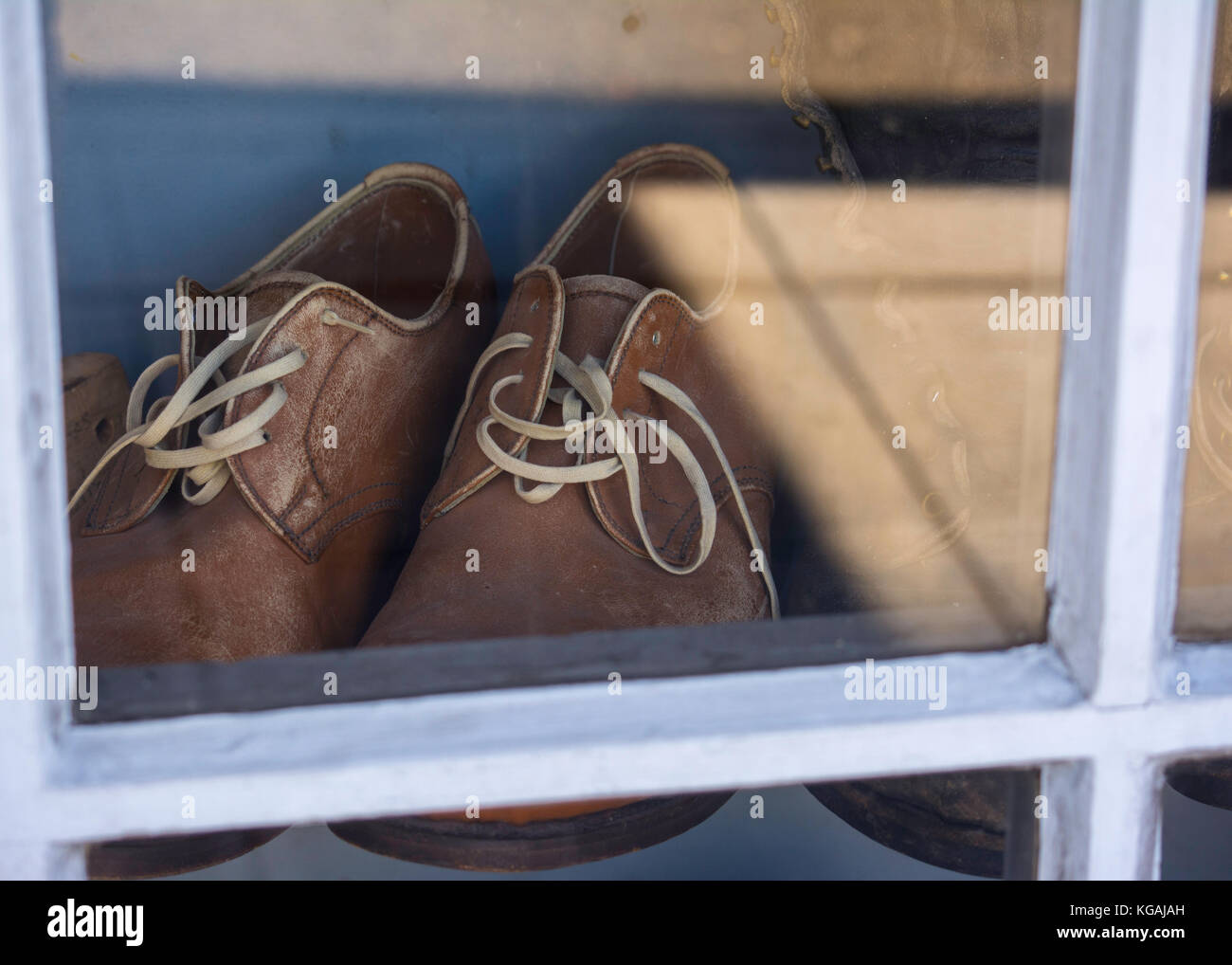 Die alten Schuhe in einem Schuh Reparatur shop Fenster mit Sommer Licht und Schatten in Seattle, Washington Stockfoto