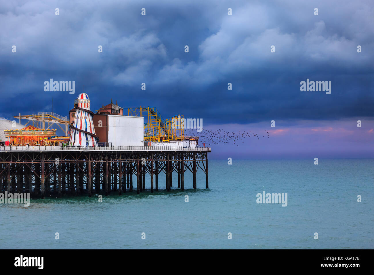 Brighton Pier Victorian Pleasure Pier Jahrmarkt vor dunklem, dramatischem Himmel und Meer Stockfoto