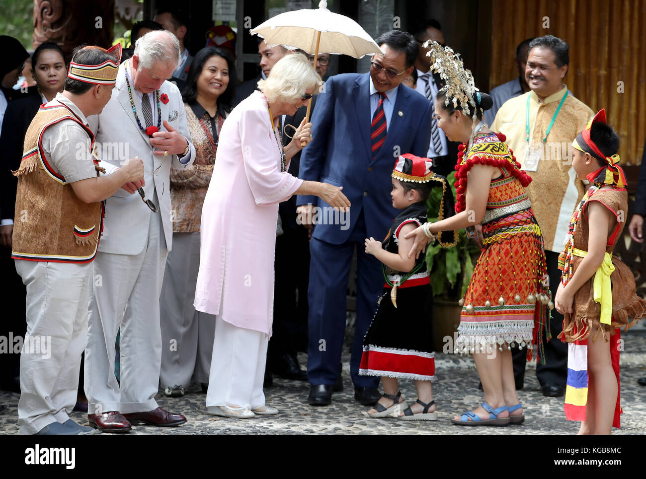 Die Herzogin von Cornwall wird von einem Kind bei einem Besuch im Sarawak Cultural Village mit dem Prince of Wales auf der letzten Etappe ihrer Tour durch den Fernen Osten begrüßt. Stockfoto