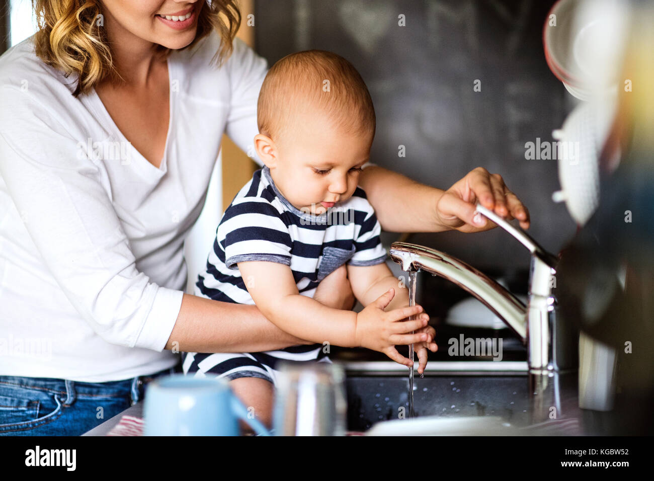 Junge Mutter mit Baby Boy, Hausarbeit. Stockfoto