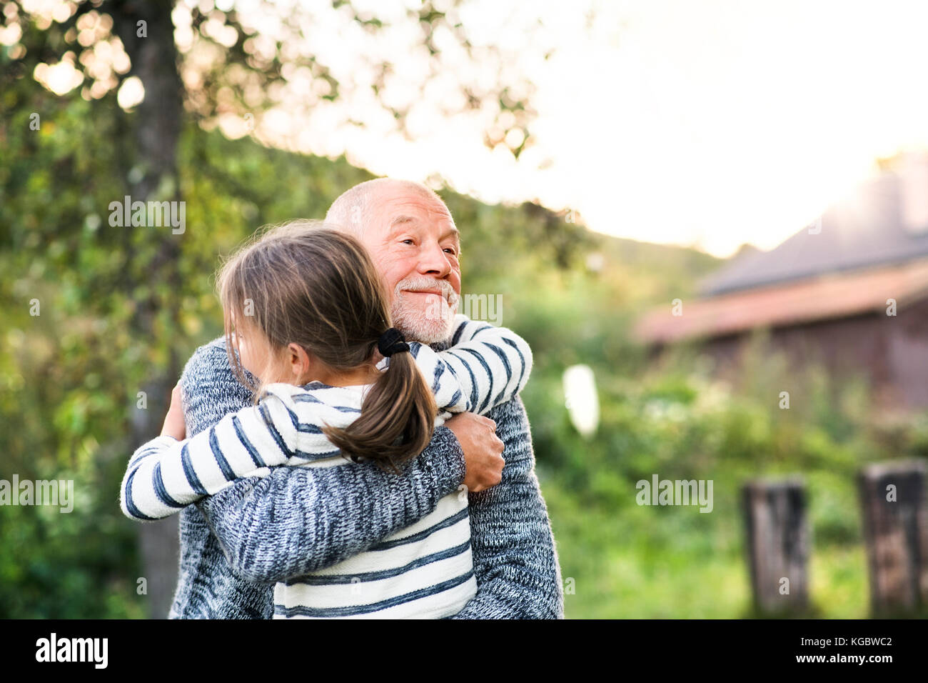 Großvater, seine Enkelin und eine Umarmung. Stockfoto