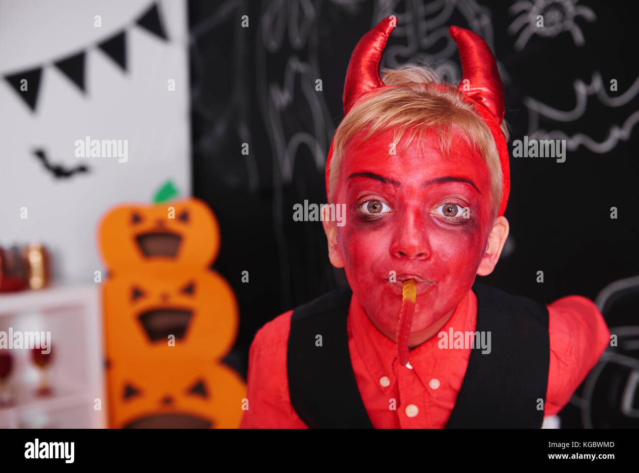 Junge in Teufel Kostüm mit Gummibärchen Worm Stockfoto