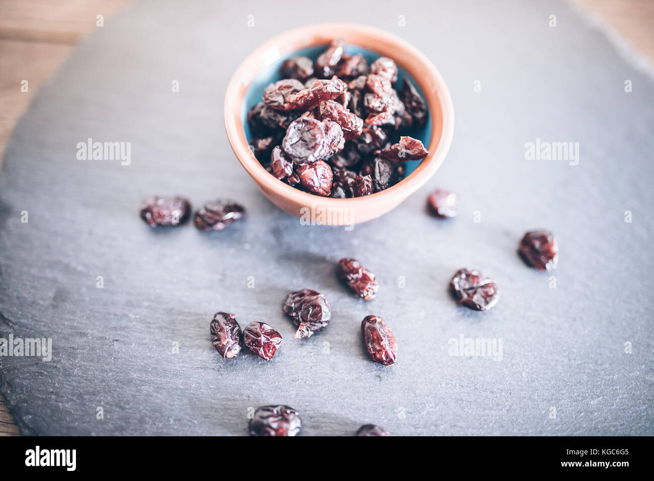 Getrocknete Cranberries in der Schüssel auf Schiefer Stockfoto