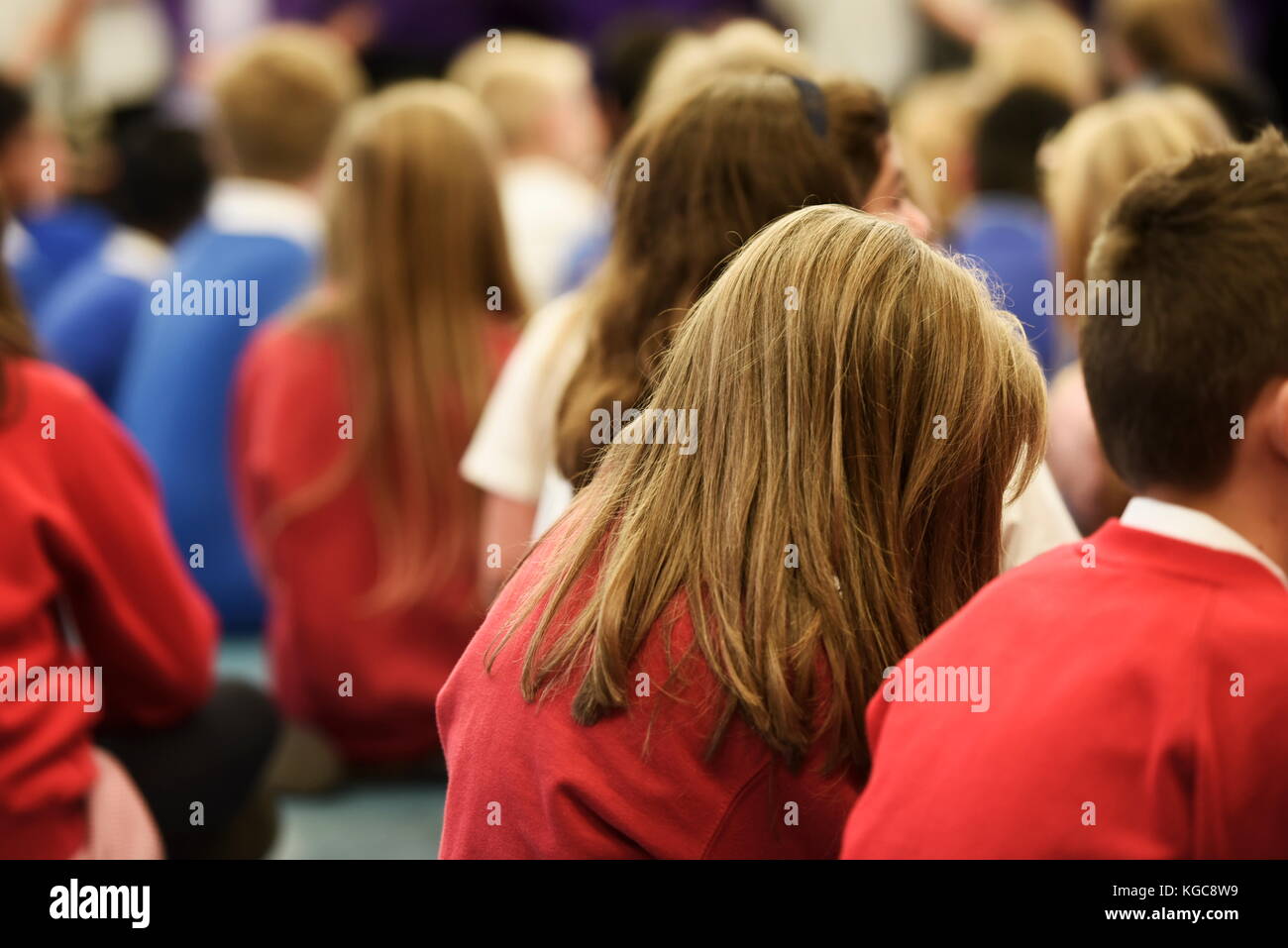 Gruppe der Schulkinder sitzen in der Montage in einer britischen Grundschule Stockfoto