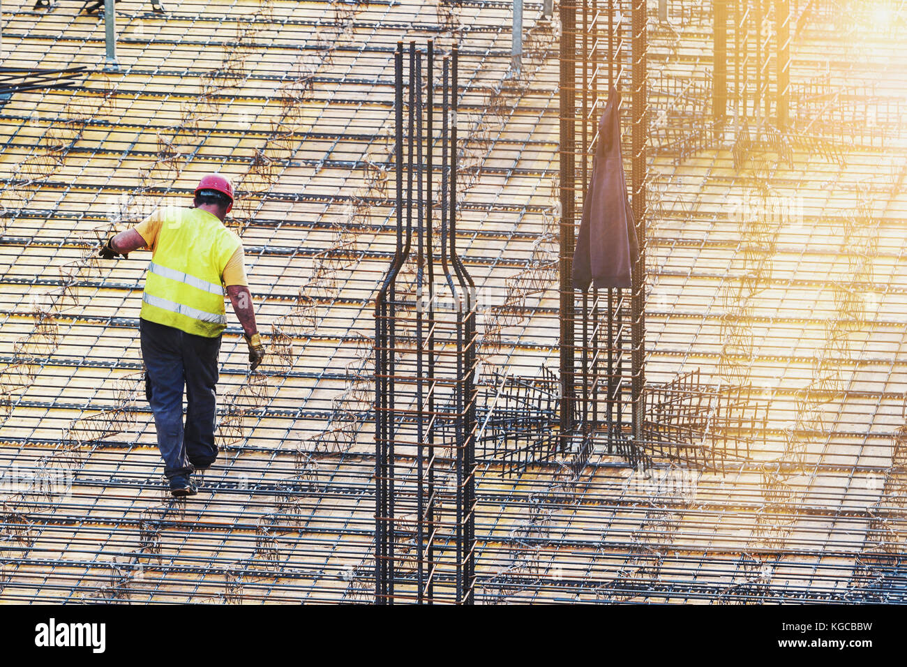 Ein Mann Arbeiter, Metall Arbeiten auf der Baustelle mit Sonnenstrahlen am frühen Morgen Stockfoto