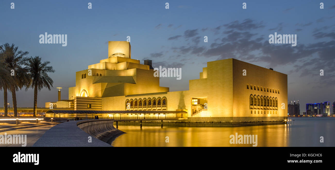 Museum für islamische Kunst, Doha, Qatar bei Nacht Außenansicht mit Licht Reflexion im Arabischen Golf mit Bäumen und Wolkenkratzer im Hintergrund. Stockfoto