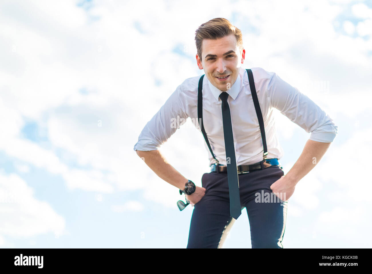 Ernsthafte junge busunessman in weißem Hemd, Krawatte, Hosenträger und  sungla Stockfotografie - Alamy