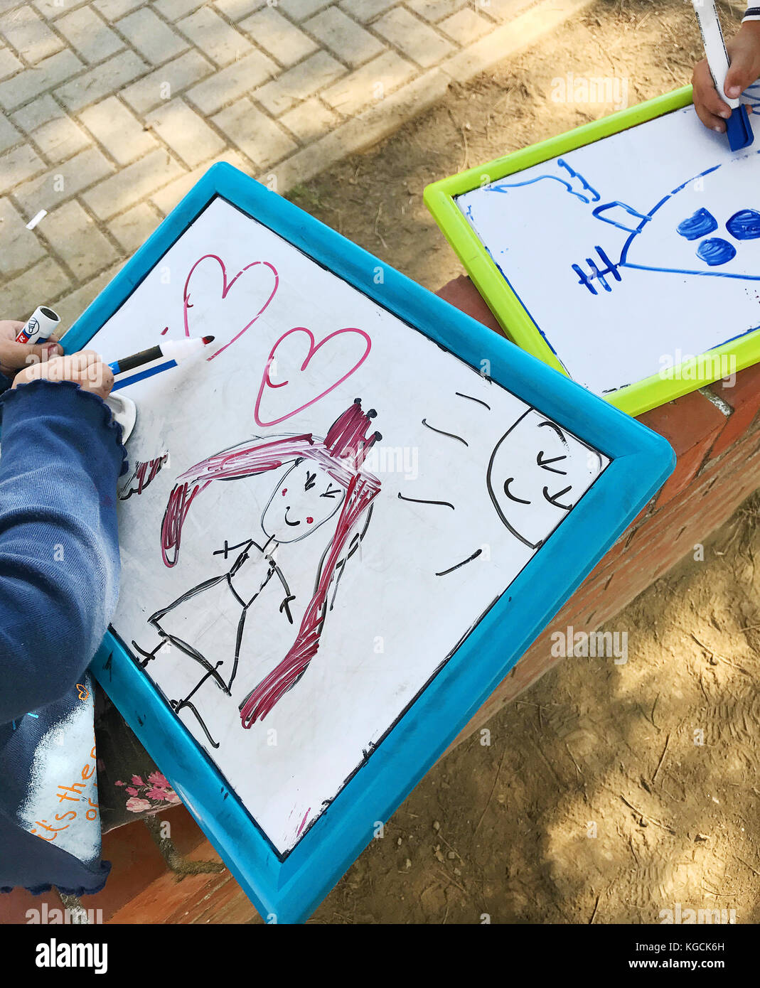 Hände von kleiner Student Zeichnung auf Whiteboards im Außenbereich. Stockfoto