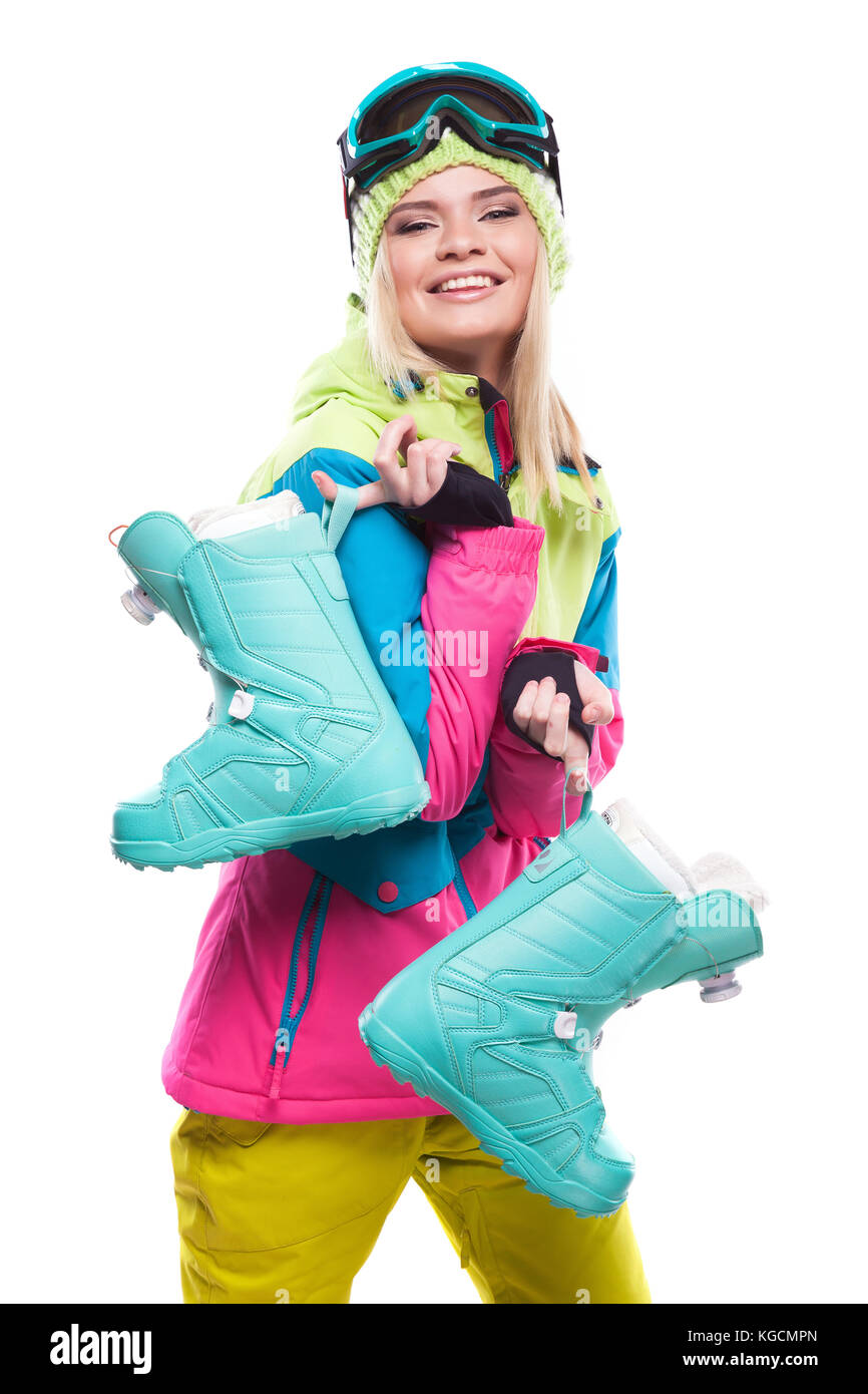 Schöne junge blonde Frau in bunten Schnee Mantel halten Schnee Stiefel Stockfoto