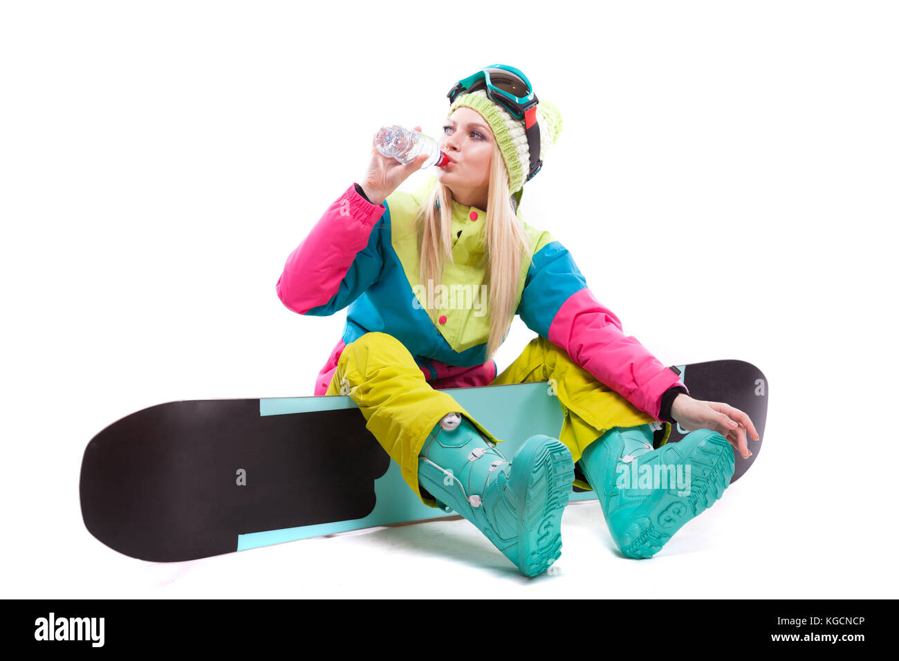 Attraktive junge Frau im Skianzug und Ski Brille sitzen auf SNOWBO Stockfoto
