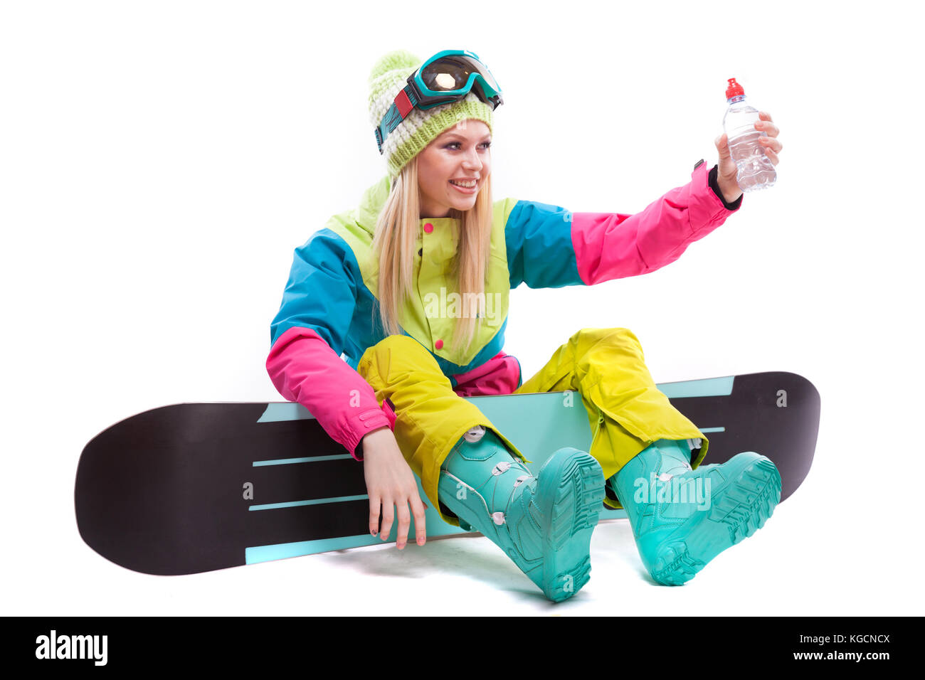 Pretty Woman in Ski Kostüm mit Flasche Wasser sitzen auf snowboar  Stockfotografie - Alamy