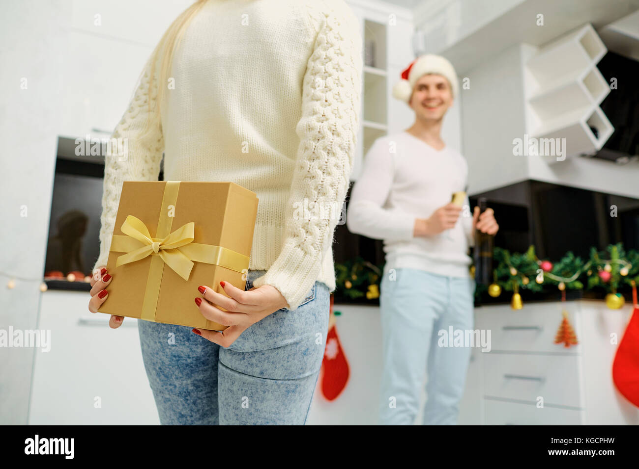 Das Paar gibt ein Geschenk in einem Weihnachten box drinnen das Zimmer Stockfoto
