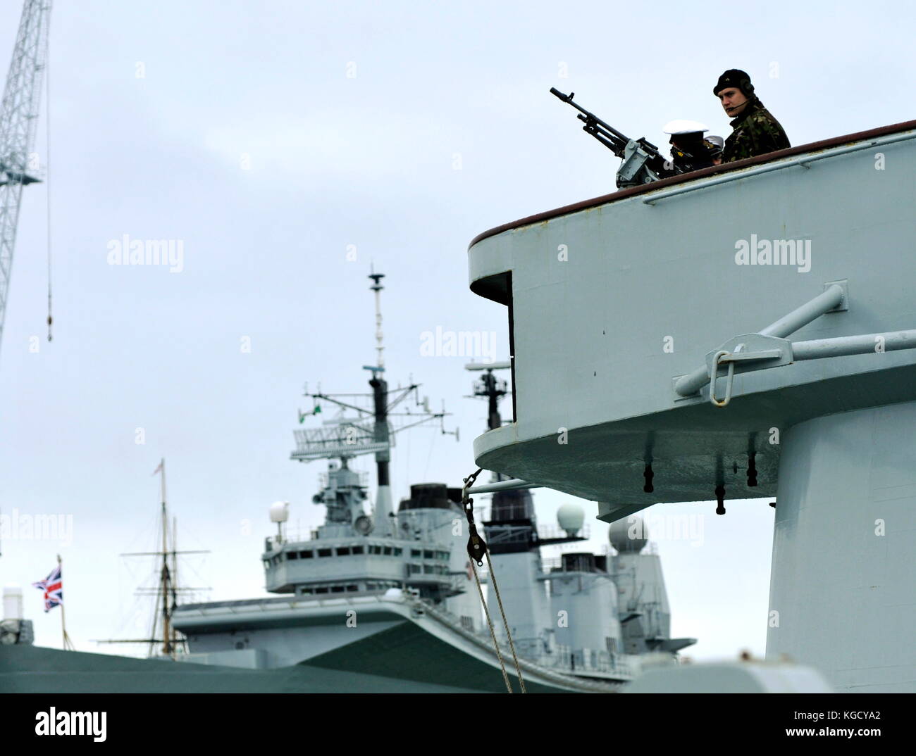 AJAXNETPHOTO. PORTSMOUTH, England. - Sicherheit - EIN ROYAL MARINE MANS EIN MASCHINENGEWEHR AUF DER BRÜCKE FLÜGEL DER MARINESCHIFF, WIE ES ZU HAFEN bereitet. Foto: Jonathan Eastland/AJAX REF: D 82306 121 Stockfoto