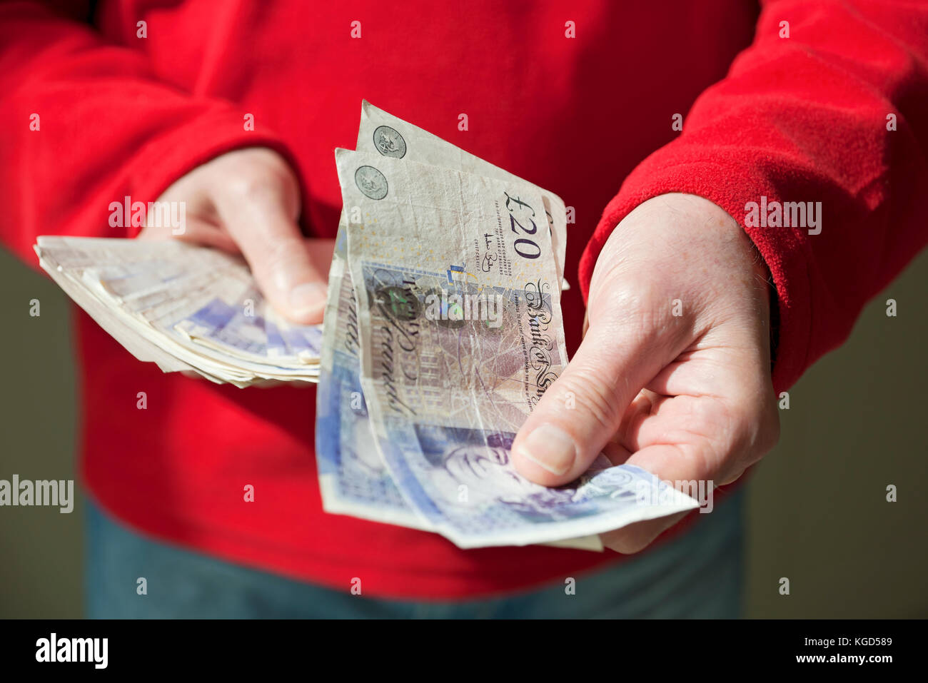 Mann mit Englisch zwanzig Pfund Noten. Stockfoto