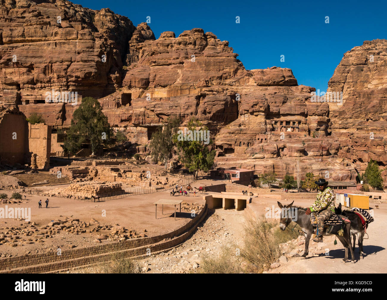 Lokaler Mann mit Esel warten auf Tarif, Qasr al-Bint, Tempel von Dushares, Petra archäologische Stätte antike Stadt, Jordanien, Naher Osten, mit blauem Himmel Stockfoto