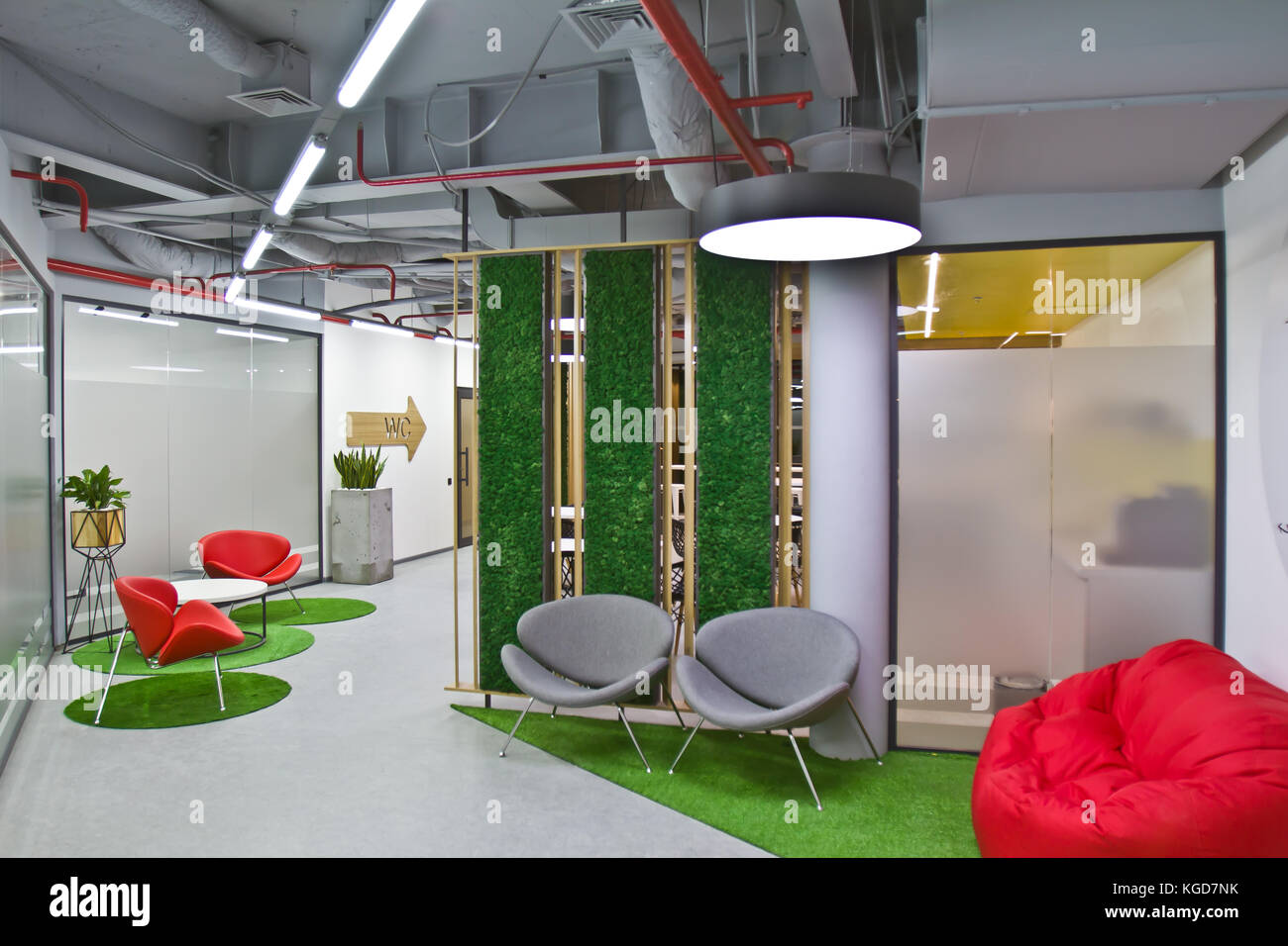 Eine luxuriöse Sitzecke in einem kleinen Büro mit moderner  Innenausstattung. Moderne Einrichtung Café mit roten Stühlen und grünen  Pflanzen Stockfotografie - Alamy