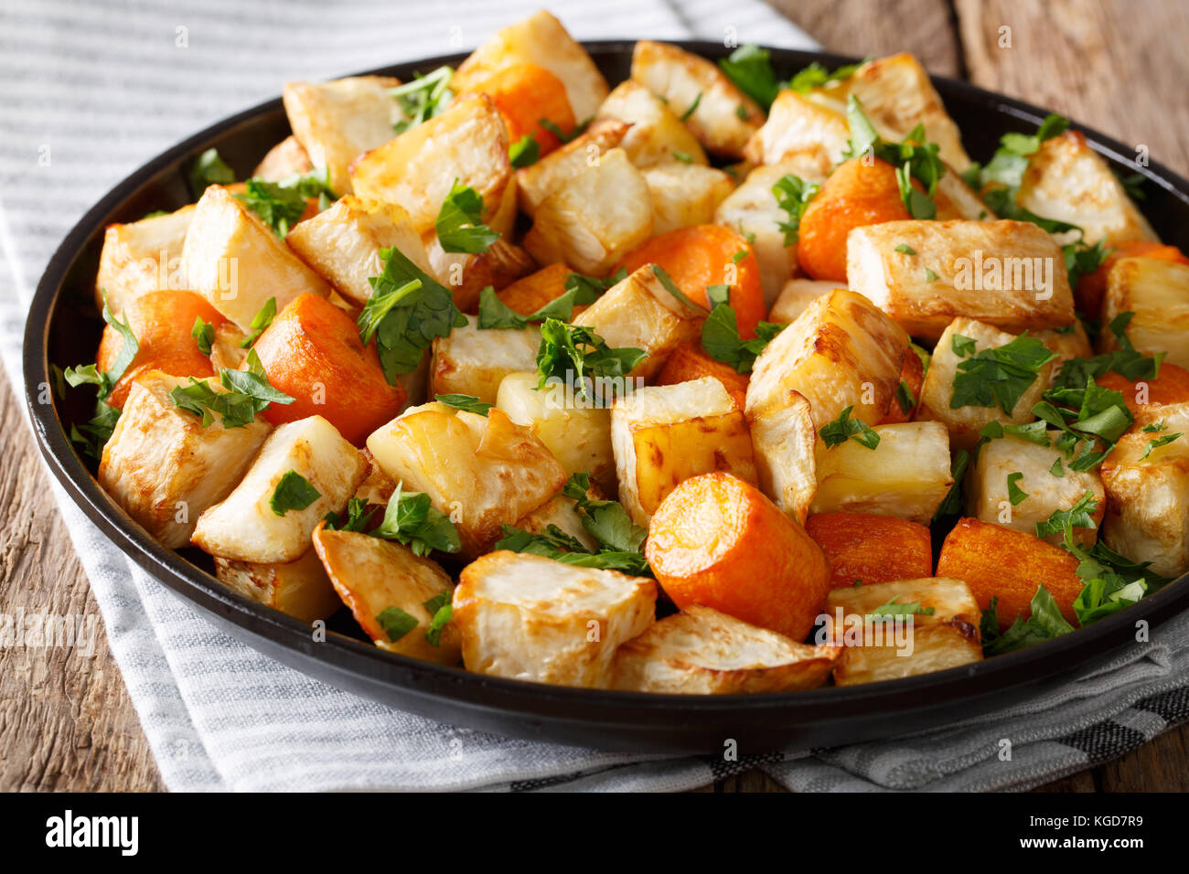 Gesund essen: gebackene Sellerie und Karotten close-up auf einem Teller auf dem Tisch. Horizontale Stockfoto