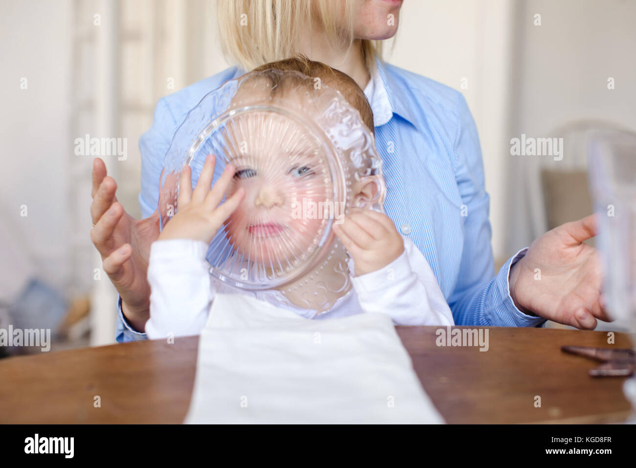Kind durch die Glasplatte Stockfoto