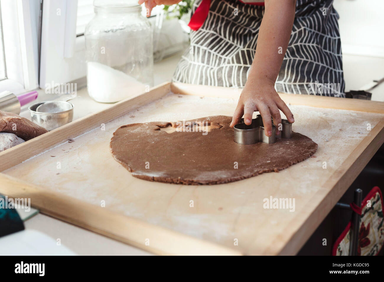 Der anonyme Kind Hände schneiden festliche Formen aus Lebkuchen Plätzchenteig. Stockfoto