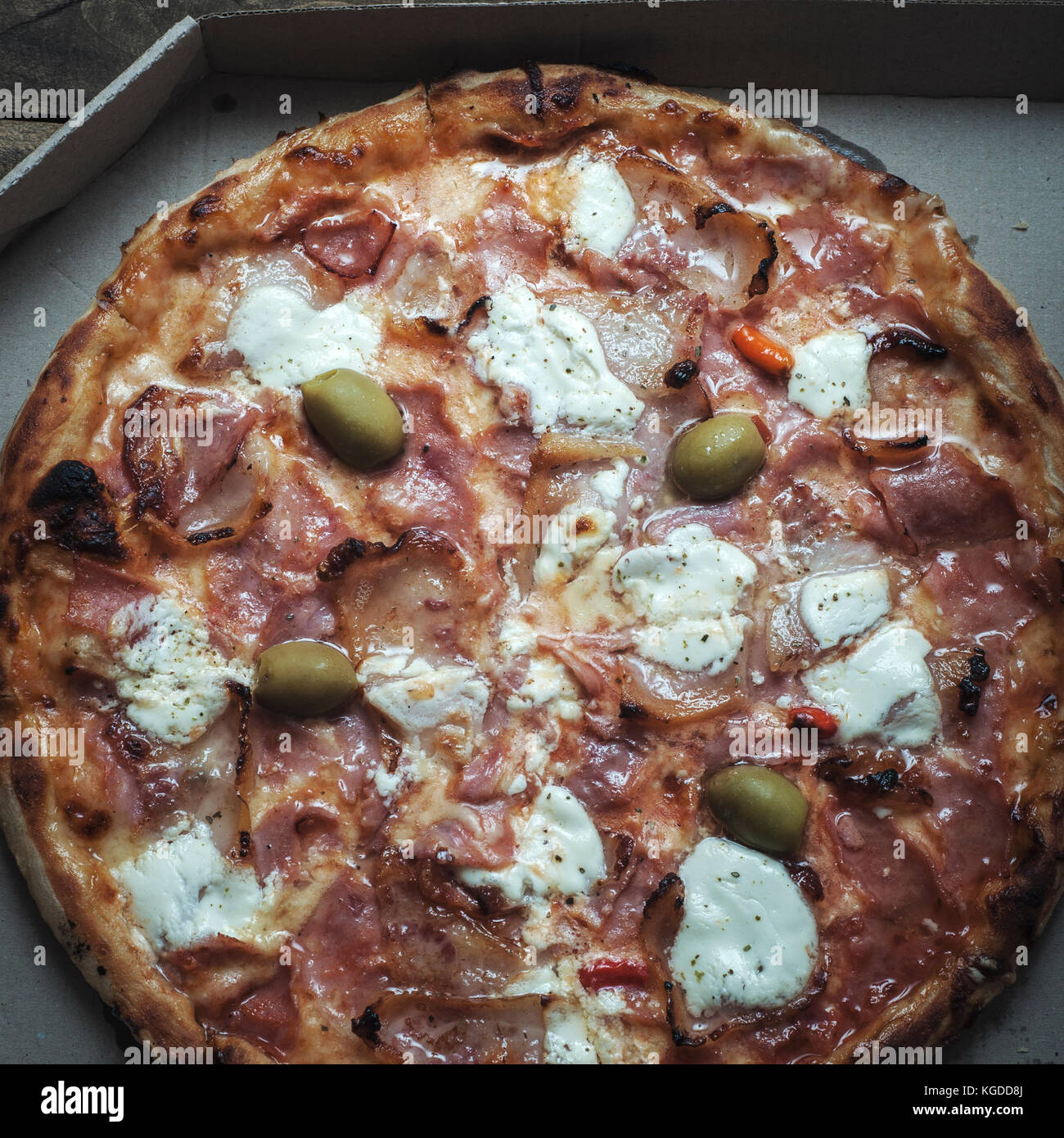 Pizza in einem Karton gegen Holz- Hintergrund. Stockfoto